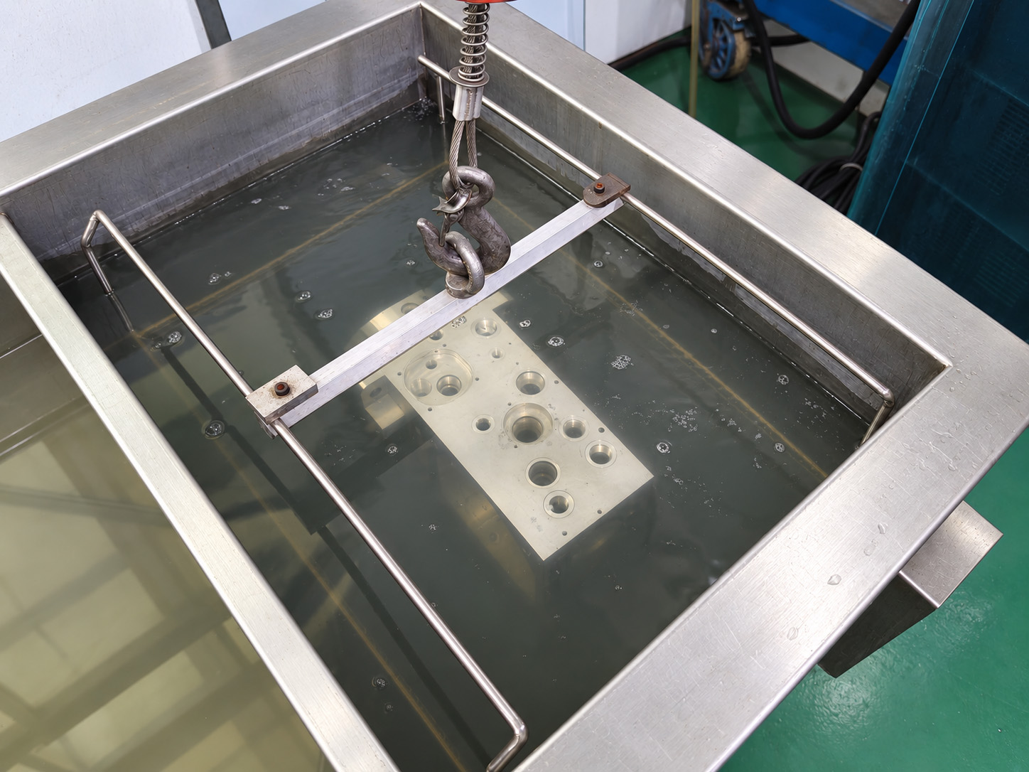 A manifold component immersed in workshop cleaning equipment.