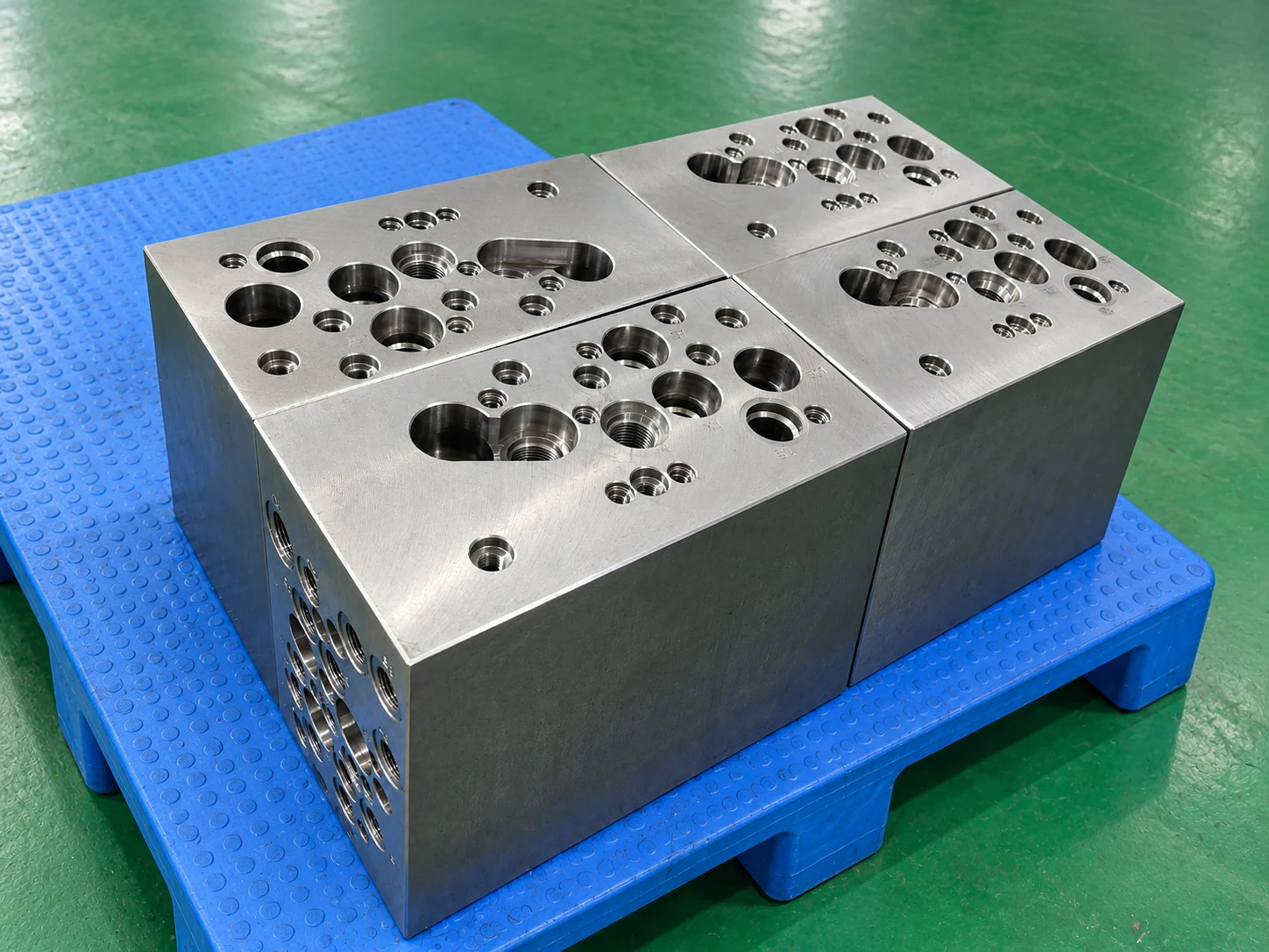Complex QT500-7 ductile iron hydraulic manifold blocks with multiple machined valve cavities and ports.