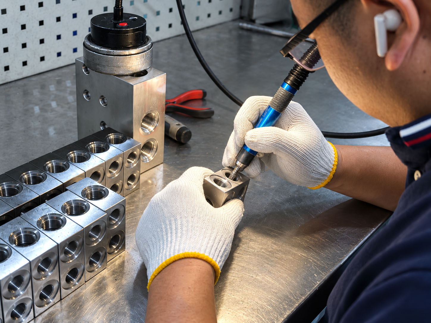 Hand finishing at accessible manifold holes in the Zhongwei workshop.